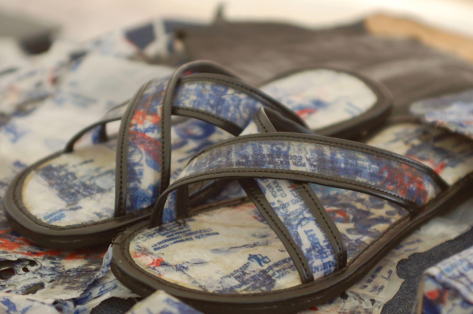 A pair of sandals with straps and soles made from layered, pressed plastic sheet